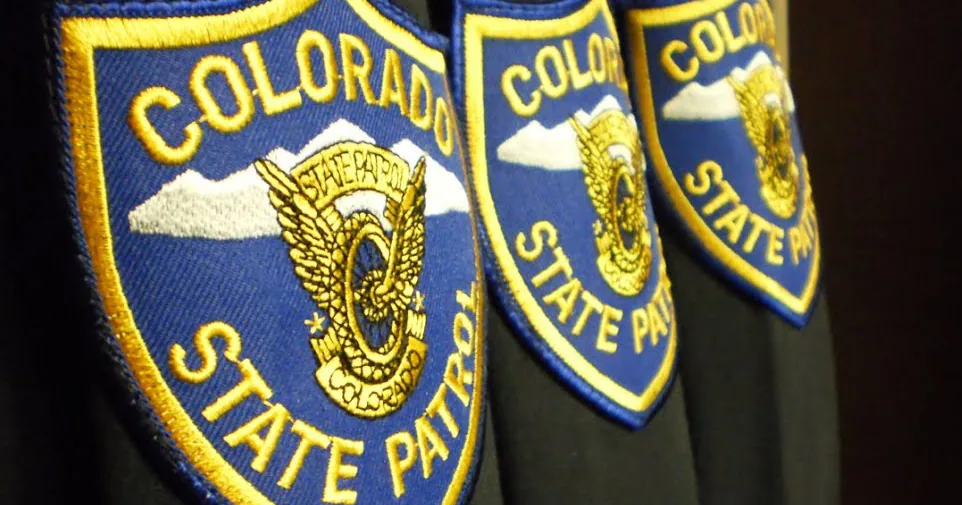 A Colorado State Patrol trooper cruiser parked with police tape near an arrest scene